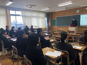 外国人の先生が高校生の前でセミナーをしている。