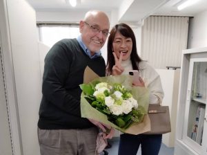 花束を持った外国人の先生と日本人生徒のリエさん