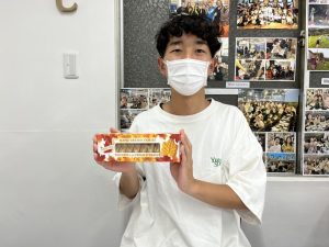 留学から帰国したメンバーさんがお土産を手に持っている