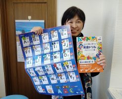 英語の発音の本を持つ女性
