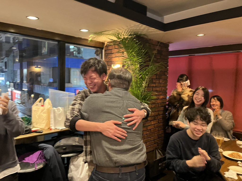 ハグされる男性とハグする外国人男性